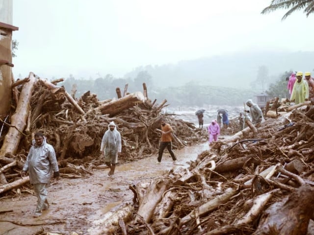 people walk past debris at a landslide site after multiple landslides in the hills in wayanad in the southern state of kerala india july 30 2024 photo reuters